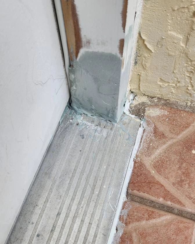 Repaired door jamb at a metal threshold