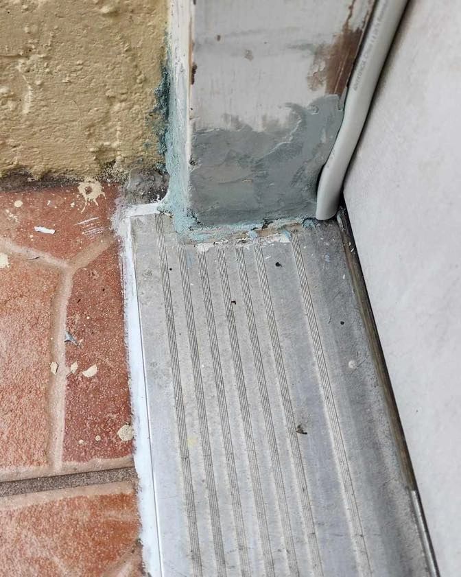 Door threshold sealed where tile meets the jamb